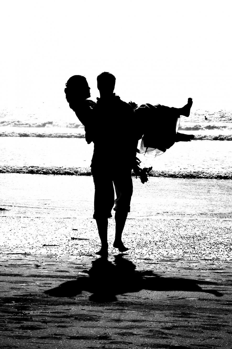 Free Image of Groom Carries Bride into Sunset 