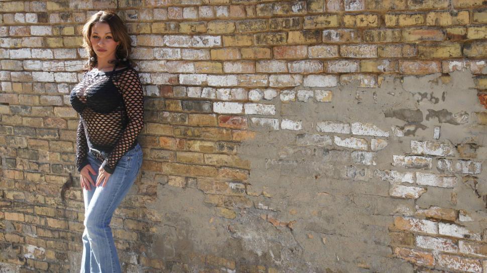 Free Image of Woman Against Brick Wall 