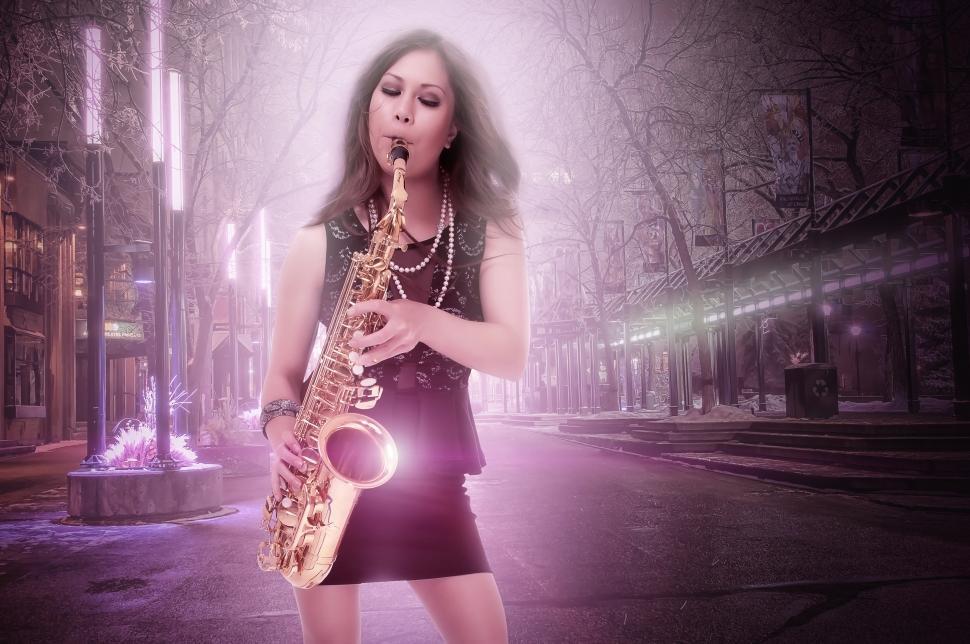 Free Image of Woman plays saxophone in the city 