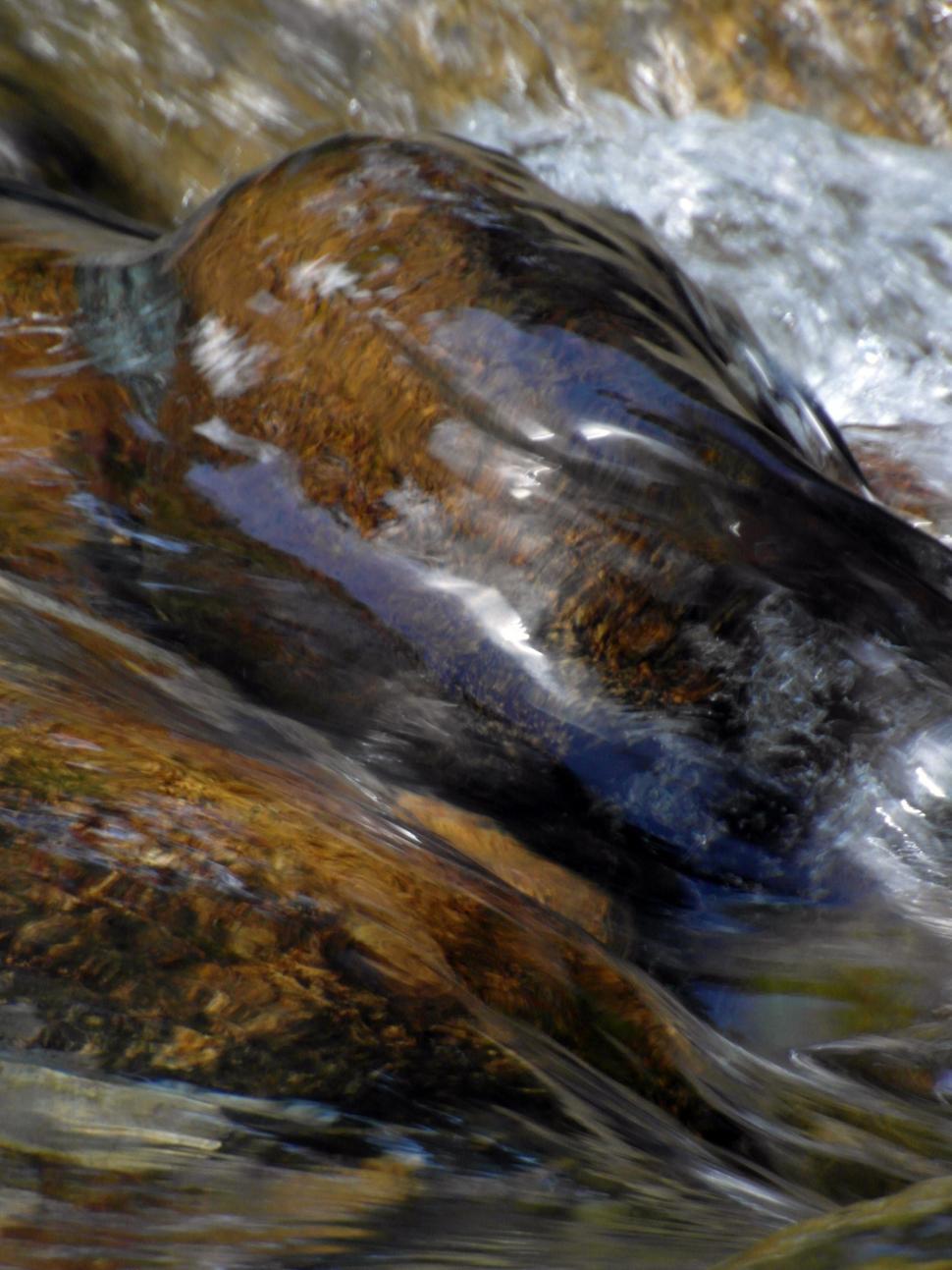 Free Image of Water rushing by smooth boulders in a river 