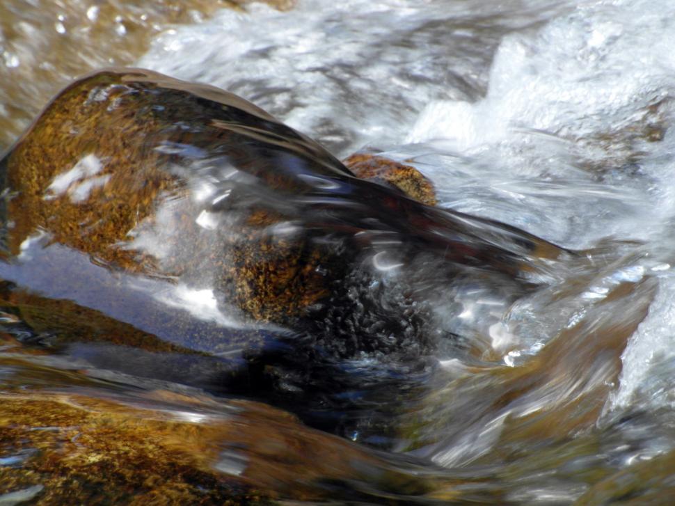 Free Image of Water rushing by smooth boulders in a river 