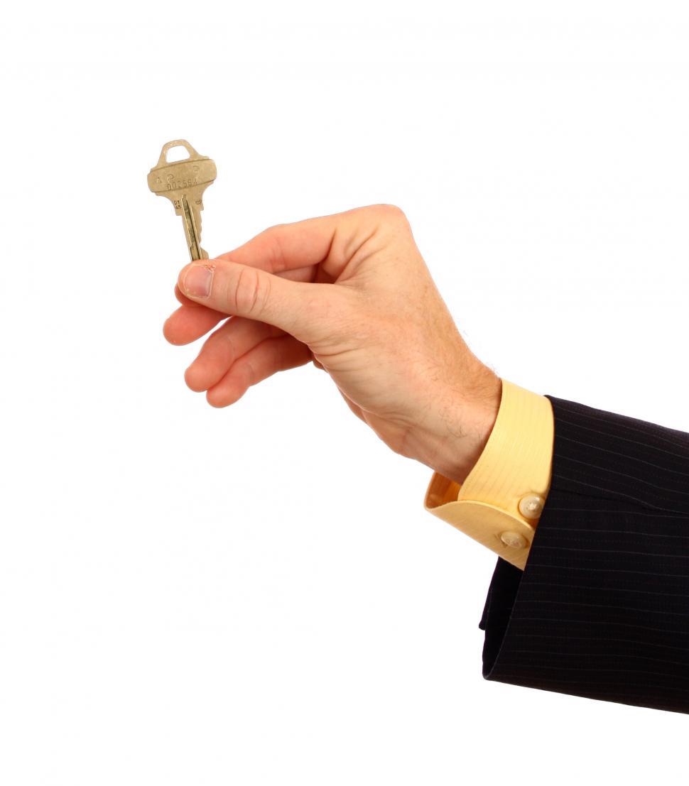 Free Image of A hand in a business suit holding a key 