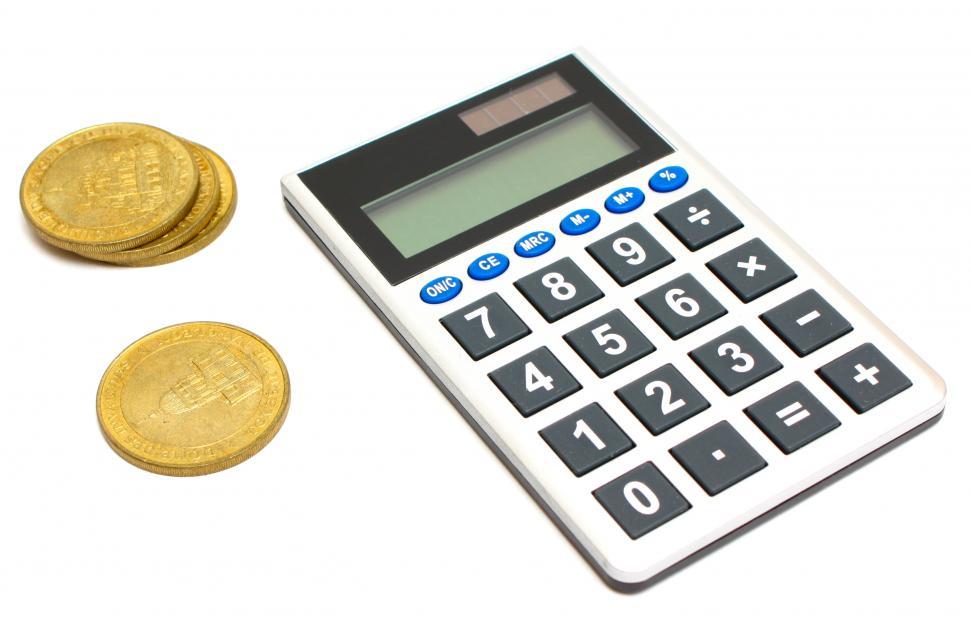 Free Image of A calculator and a stack of gold coins 