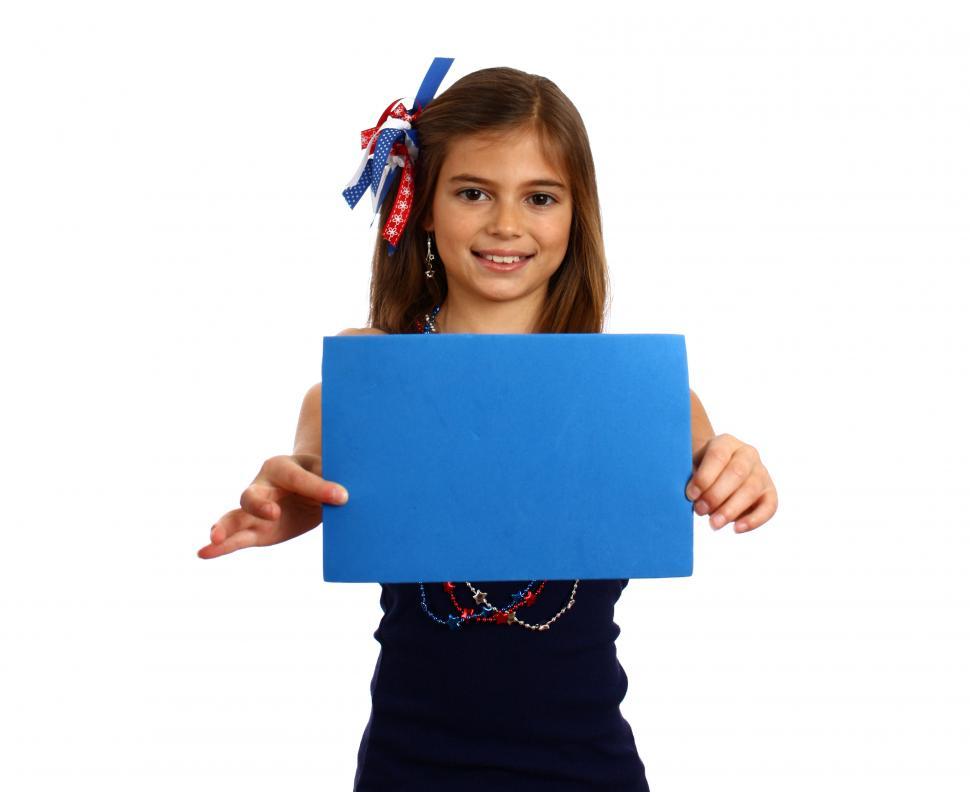 Free Image of A pretty young girl dressed for the 4th of July holding a blank blue sign 