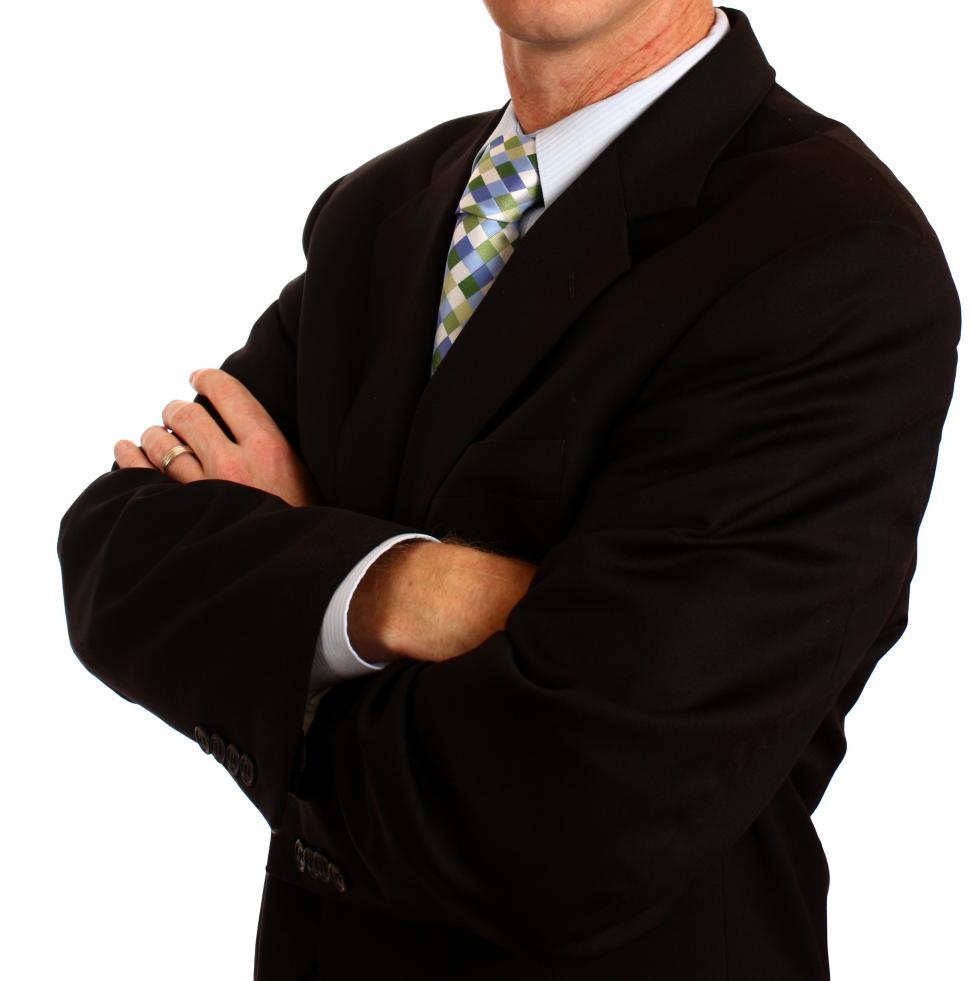 Free Image of A young businessman in a suit crossing his arms 