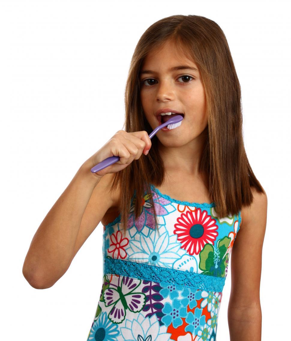 Free Image of A pretty young girl brushing her teeth 