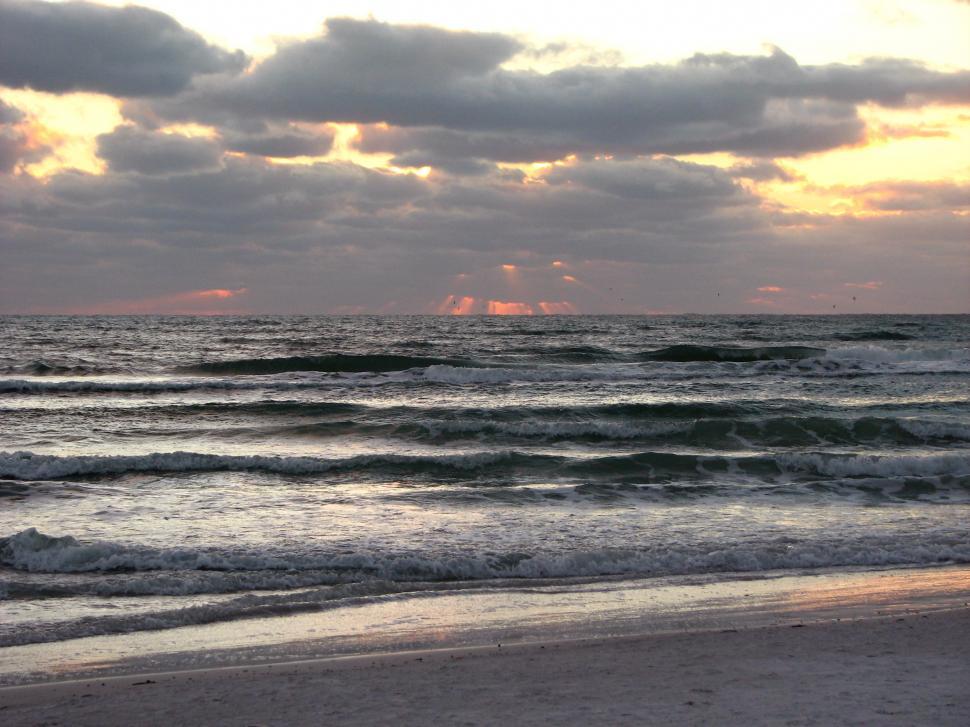 Free Image of A cloudy sunset over the ocean 