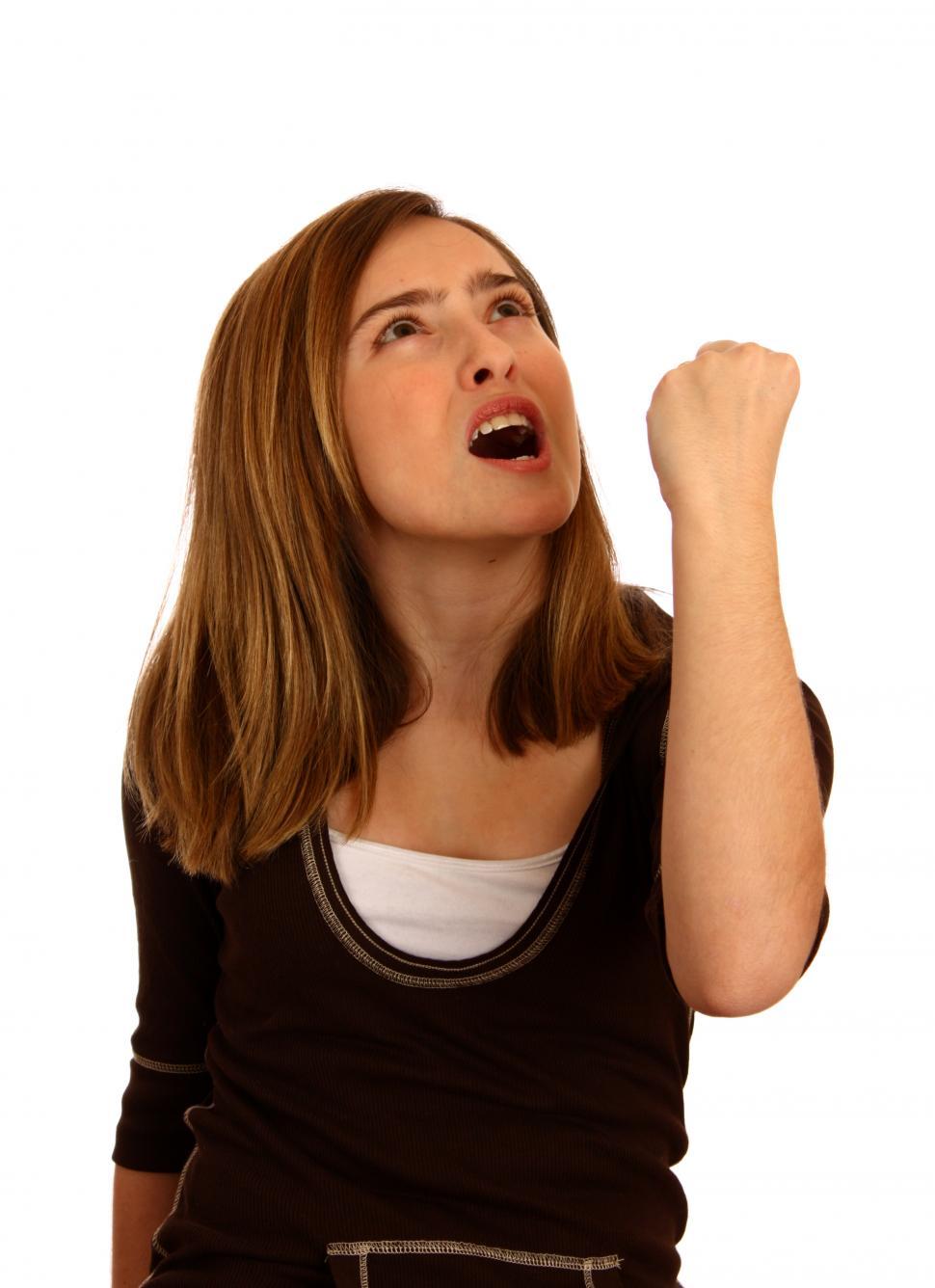 Free Image of A cute young girl posing with an angry expression making a fist 