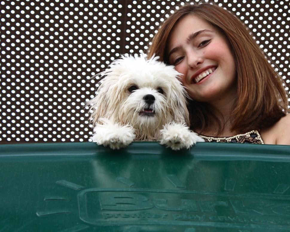 Free Image of A beautiful young girl playing on a playground with a dog 