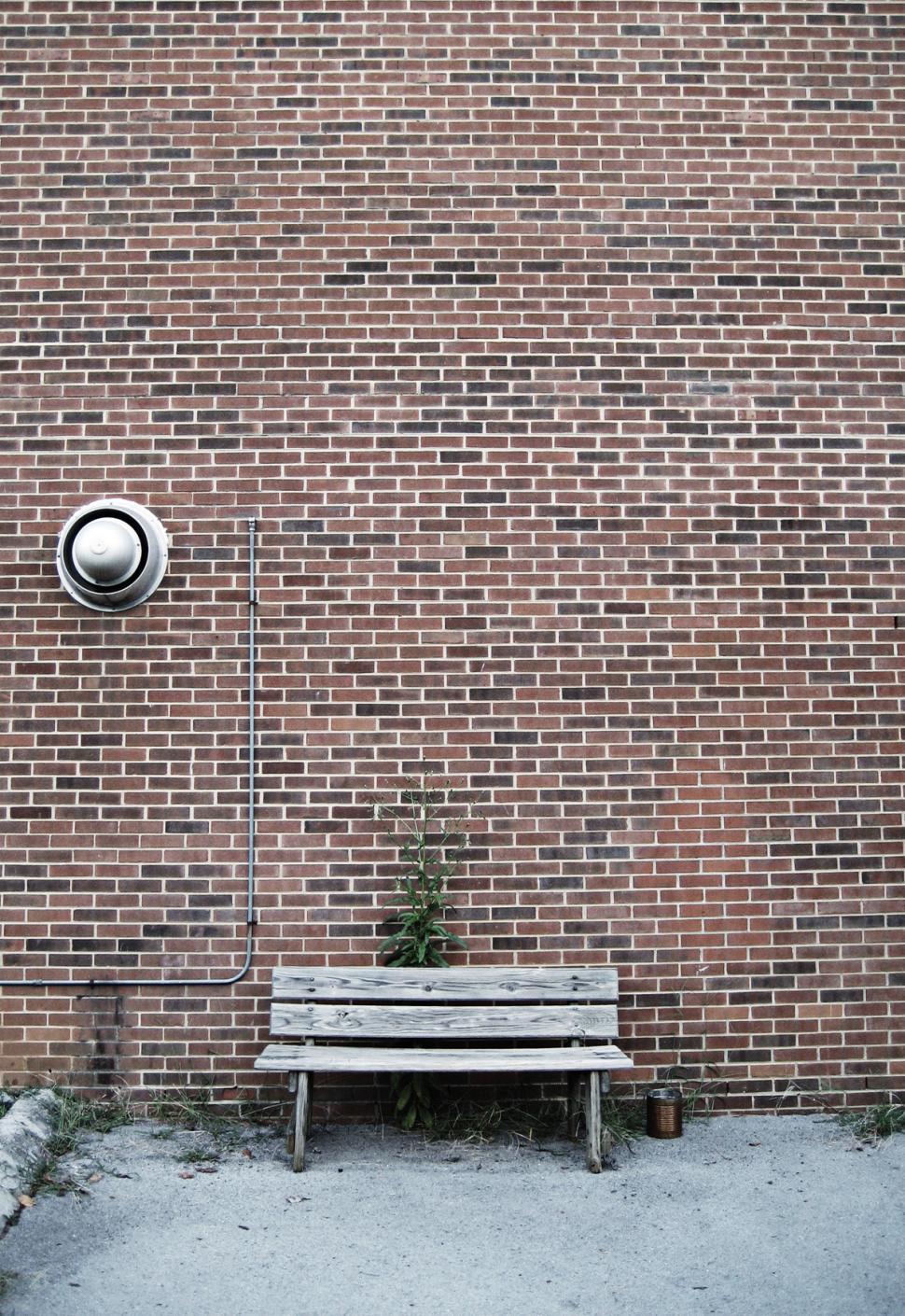 Free Image of Wooden Bench in Front of Brick Wall 
