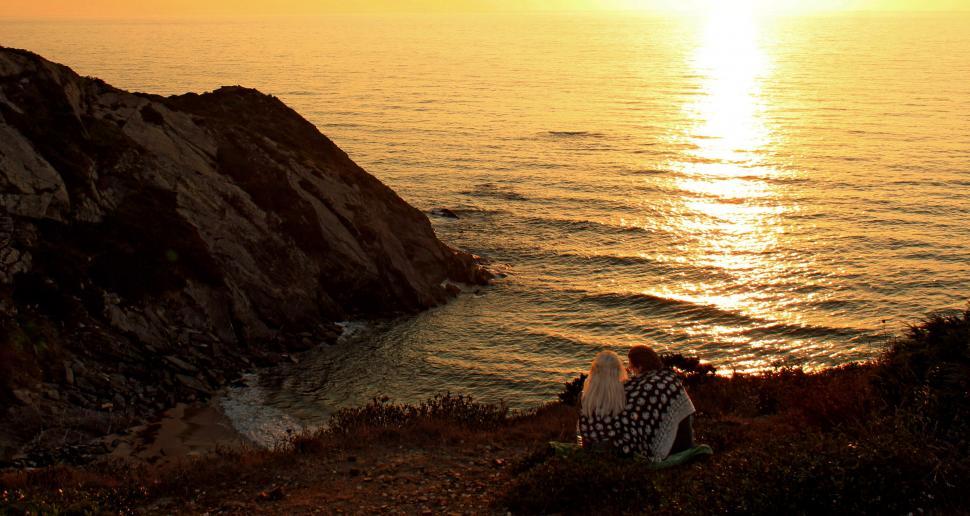 Free Image of Two lovers watching a fiery sunset in Algarve, Portugal 