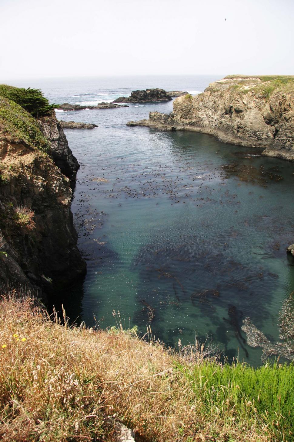 Free Image of Rocky Cliff Surrounding Body of Water 