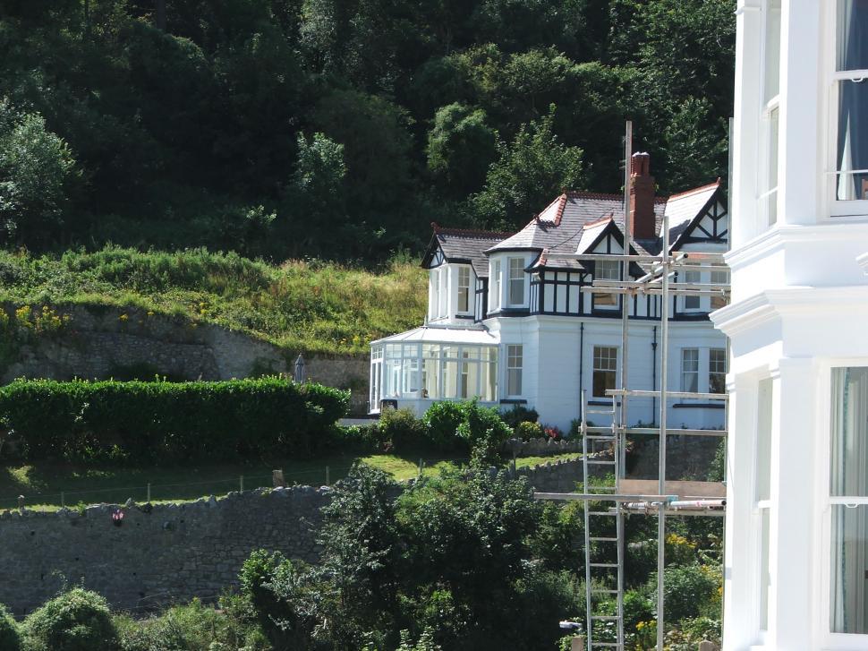 Free Image of Large White House on Lush Green Hillside 