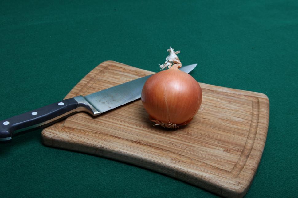 Free Image of Knife and Onion on wooden cutting board. 