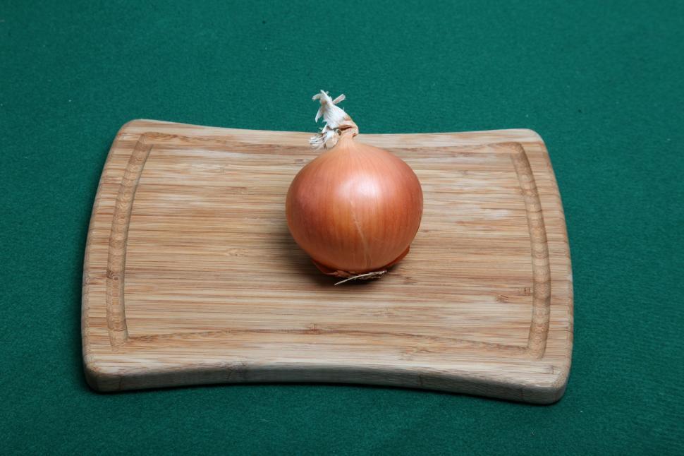 Free Image of Onion on wooden cutting board. 