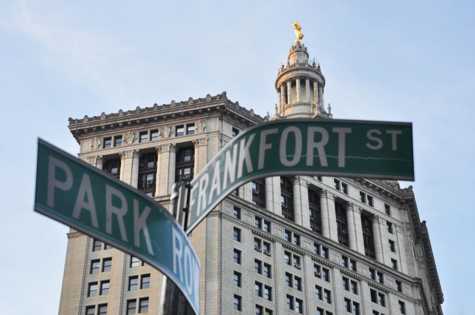 Free Image of Street Sign in Front of Tall Building 