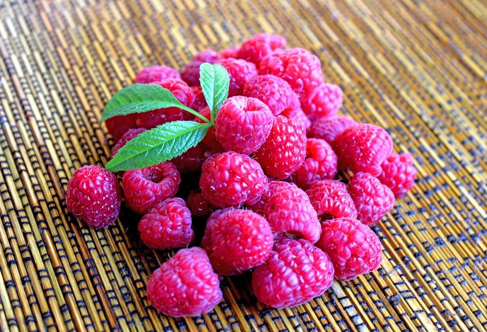 Free Image of Raspberries on table with leaves 