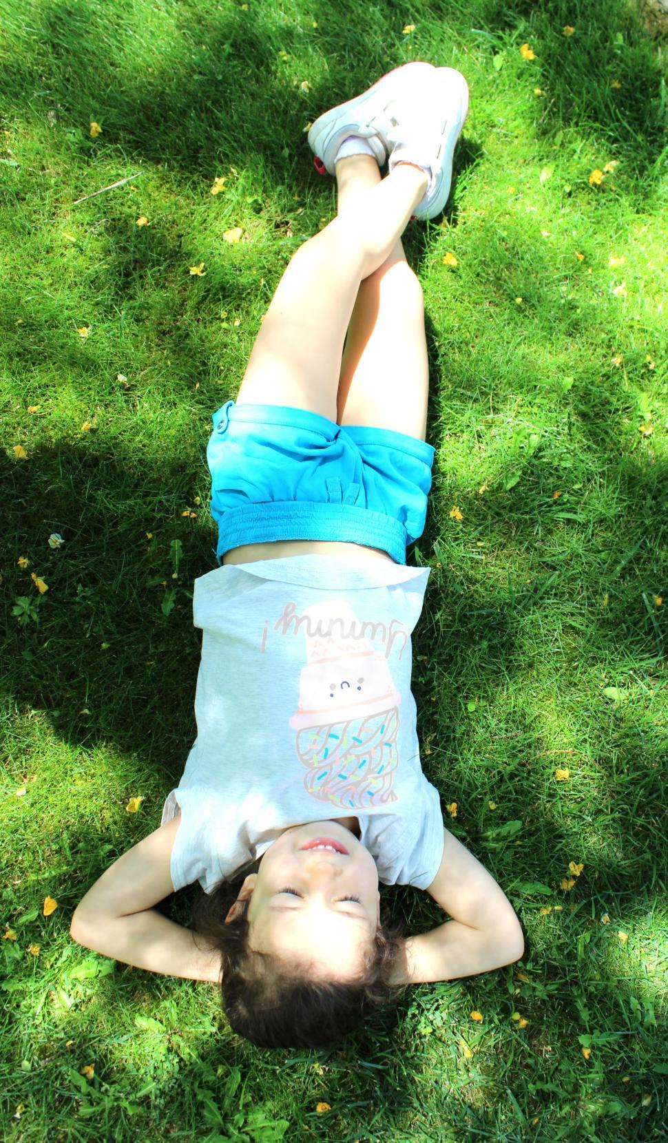 Free Image of Sweet girl relaxing on the grass - Top View 