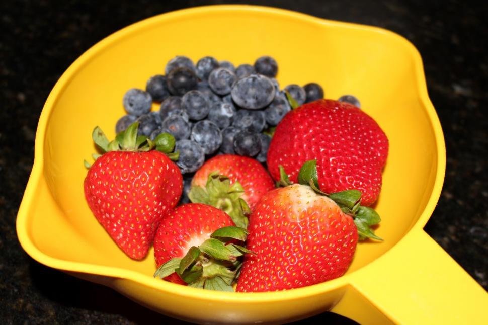 Free Image of Strawberries and Blueberries in a yellow Colander.  
