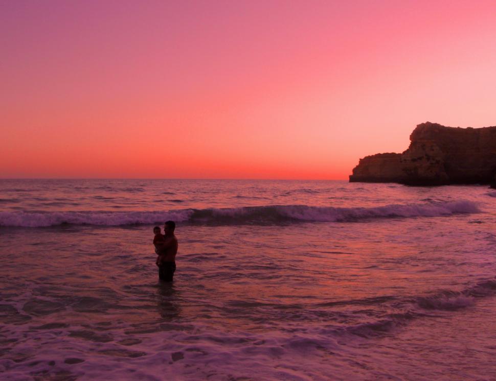 Free Image of Father bathing with his baby daughter at sunset in Praia da Mari 
