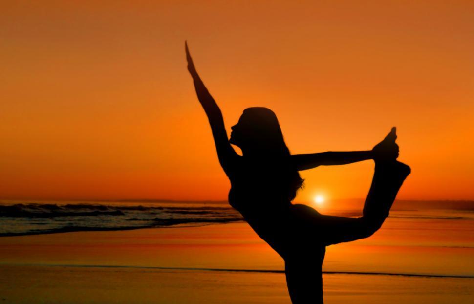Free Image of Healthy young woman practicing yoga at sunset on the beach  