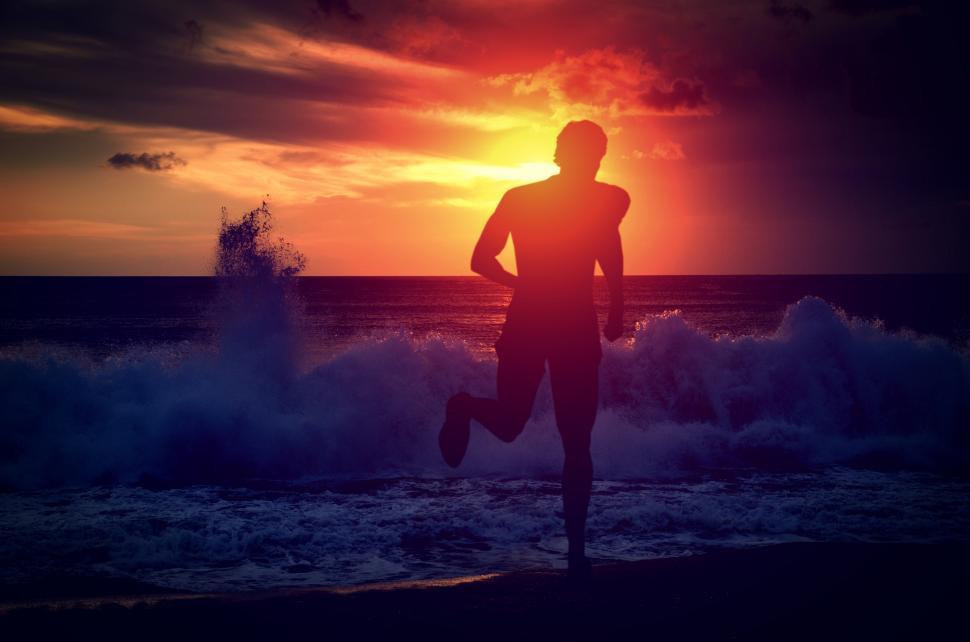 Free Image of Man running on the beach at sunset 