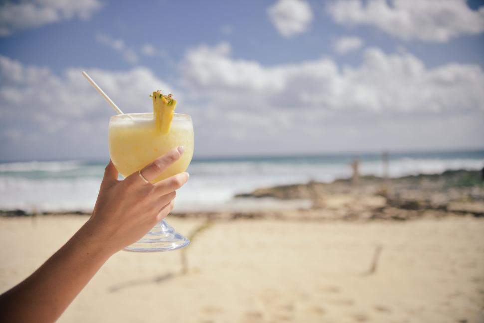 Free Image of Hand holding a glass of tropical fruit juice 
