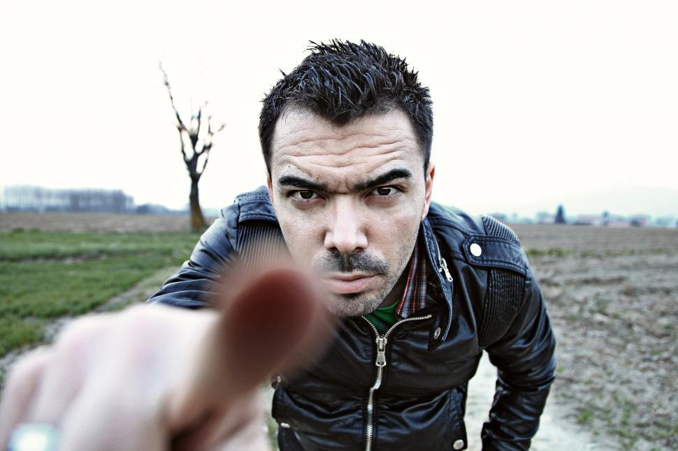 Free Image of Man looking at the camera, pointing his finger at the viewer 