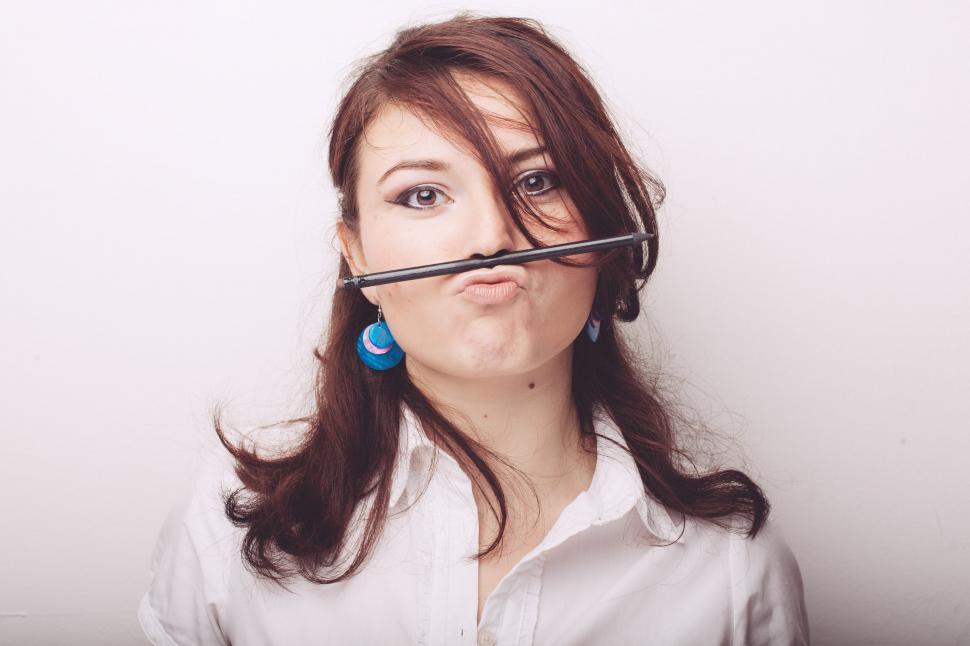 Free Image of Woman Holding Pair of Scissors in Mouth 