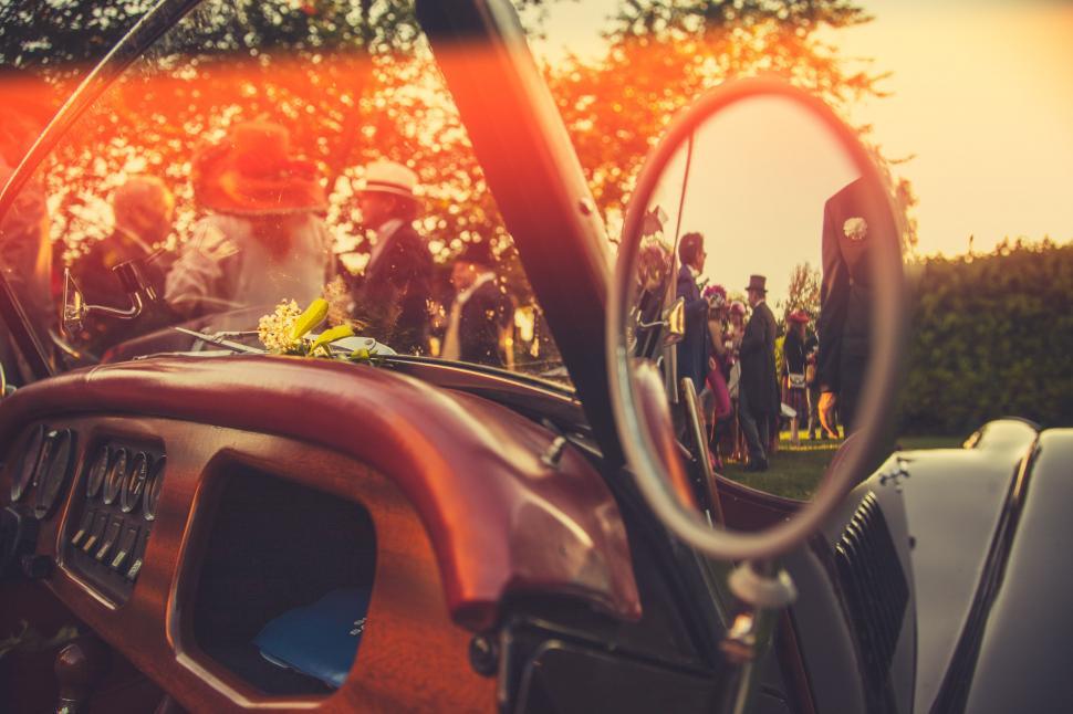 Free Image of Group of People Standing Around Red Car 