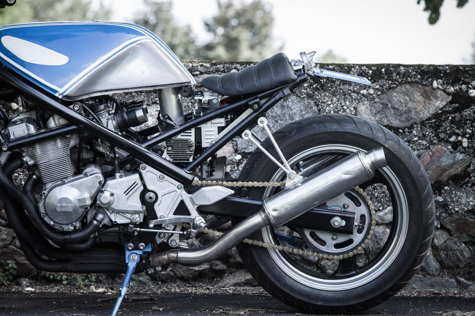 Free Image of Blue and Silver Motorcycle Parked Next to Stone Wall 