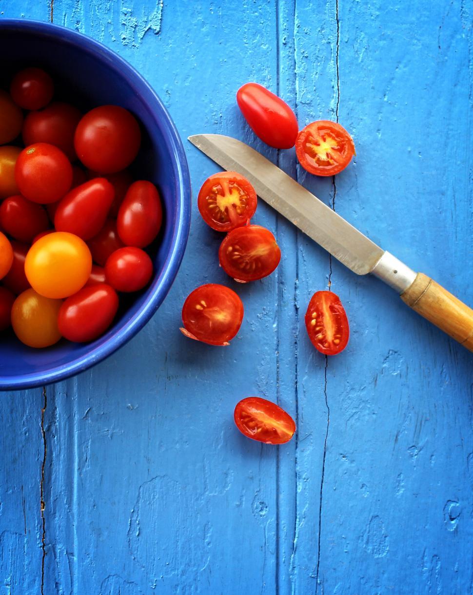 Free Image of Freshly sliced organic cherry tomatoes on blue wooden background 