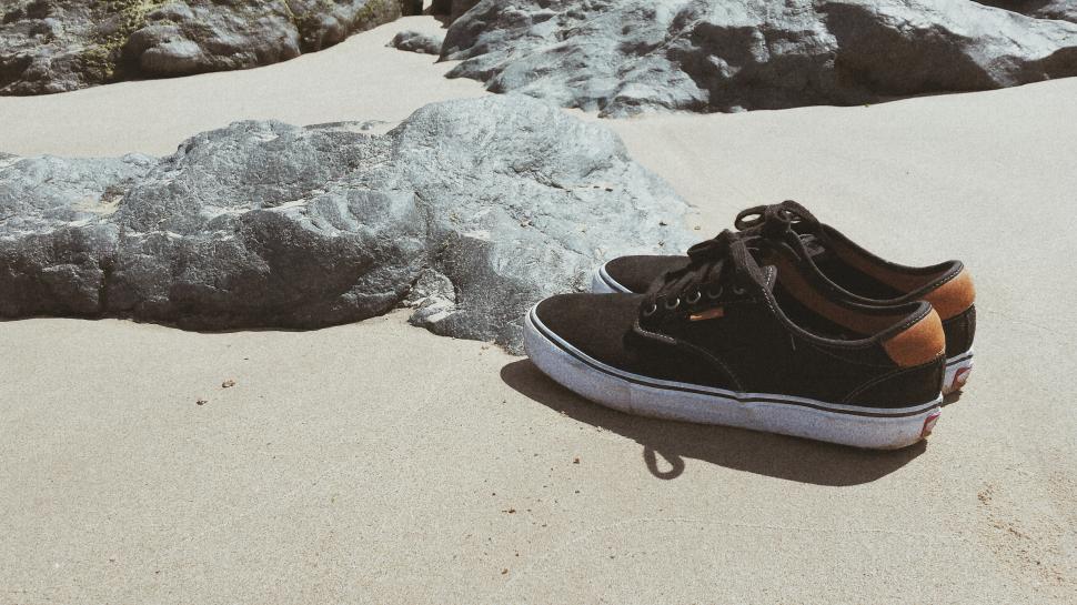 Free Image of Shoes Resting on Sandy Beach 