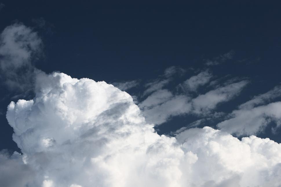 Free Image of A Plane Flying Through a Cloudy Blue Sky 