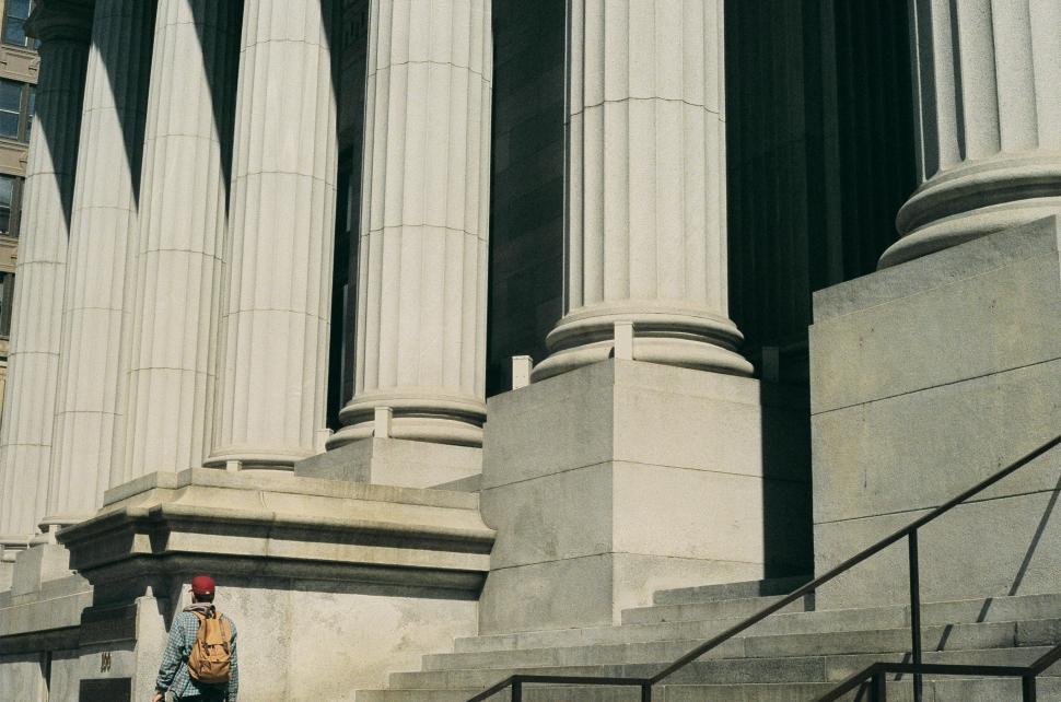 Free Image of Person Walking Up Steps in Front of Building 