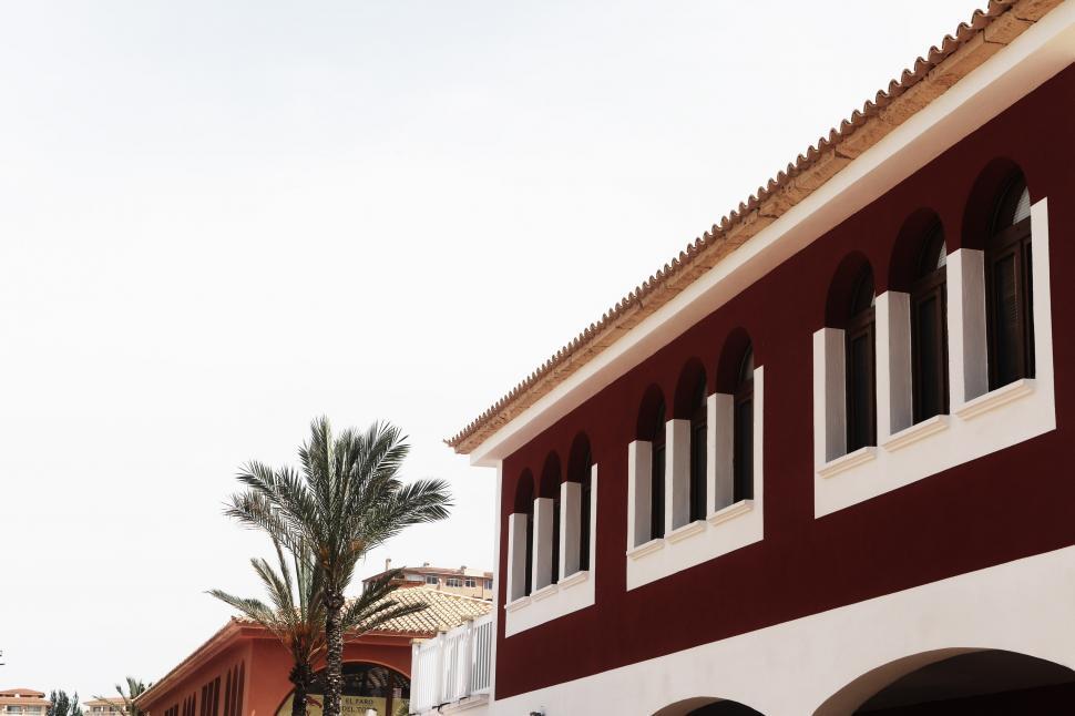 Free Image of Red and White Building With Palm Trees 
