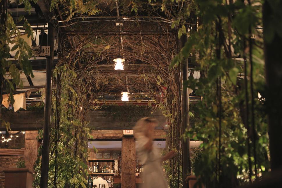 Free Image of Woman in White Dress Walking Through a Building 