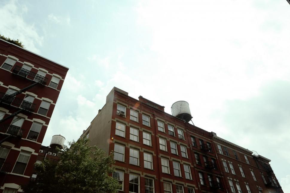Free Image of Tall Red Brick Building Next to Traffic Light 