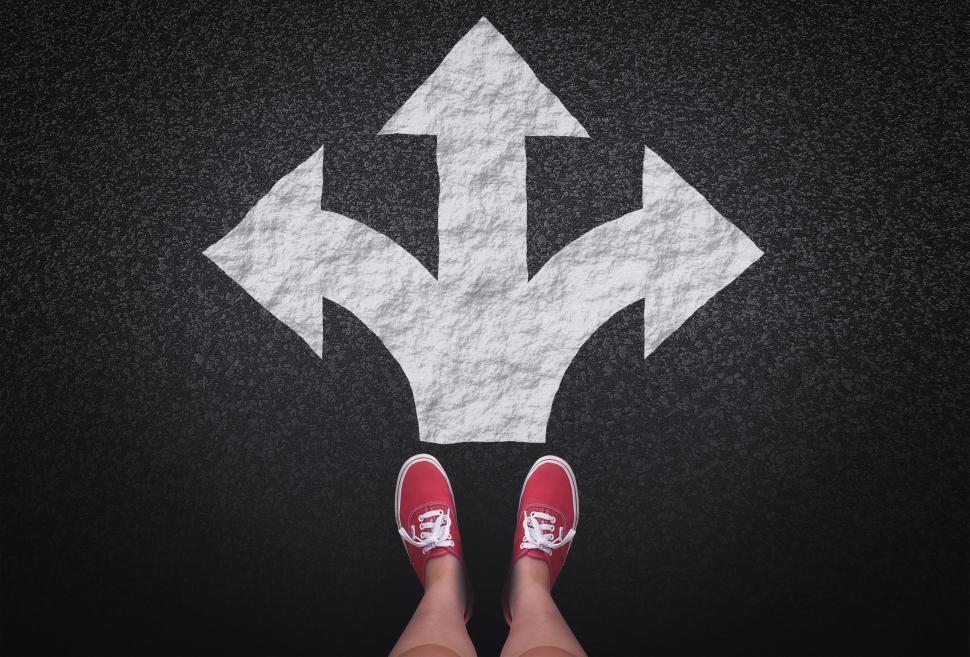 Free Image of At a crossroads - Decisions and choices concept with large arrow 