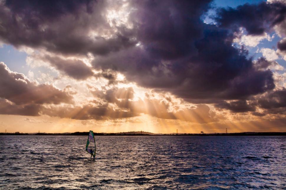 Free Image of Man Riding Surfboard on Body of Water 