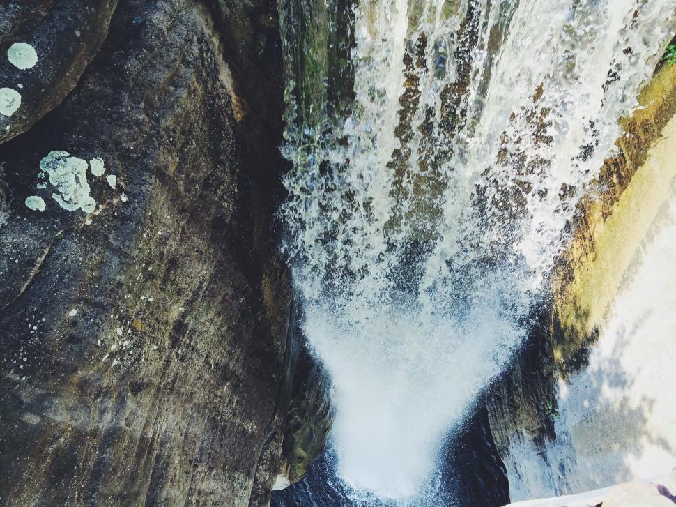 Free Image of Man Standing in Front of Waterfall 