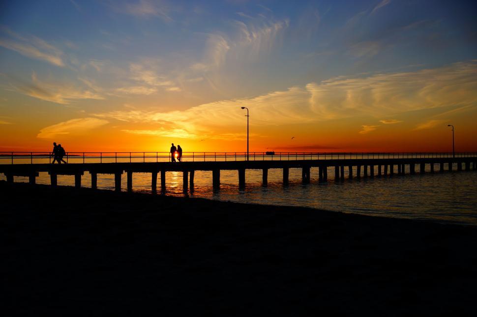 Free Image of Couple Walking Across Bridge Over Water 