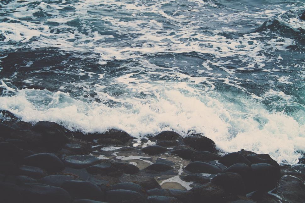 Free Image of Man Standing on Rocky Beach Near Ocean 