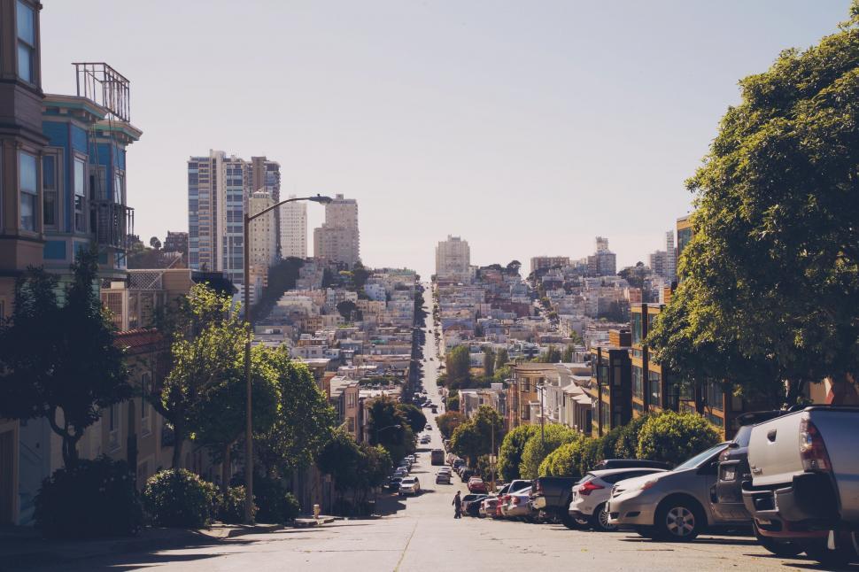 Free Image of City Street Lined With Parked Cars and Tall Buildings 