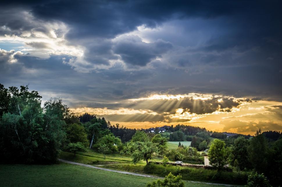 Free Image of Sun Shining Through Clouds Over Field 