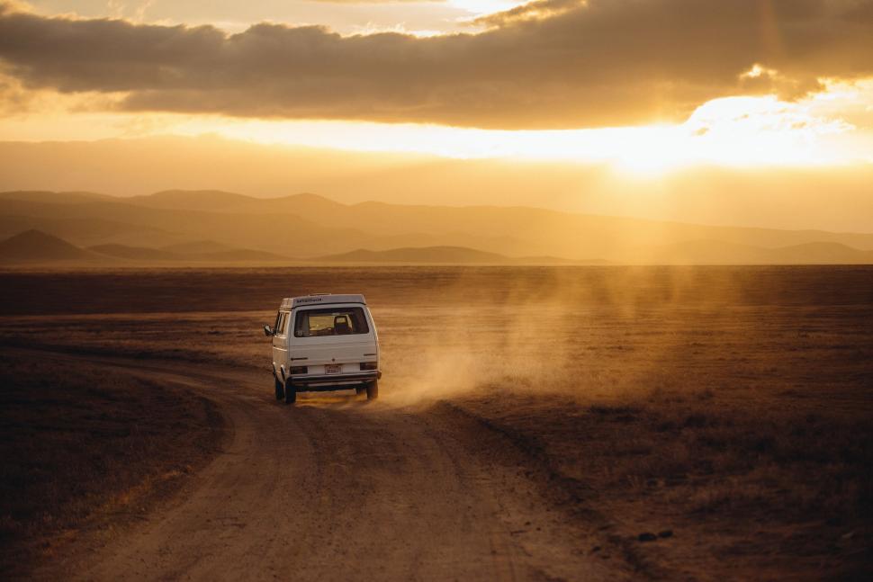 Free Image of White Van Driving Down Dirt Road 