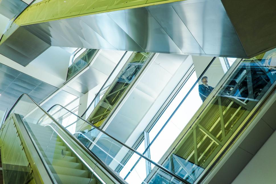 Free Image of Man Riding Escalator Down Stairs 