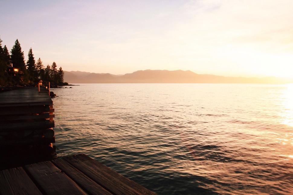 Free Image of Sun Setting Over Water at Dock 