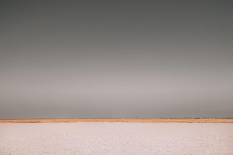 Free Image of Person Standing on Beach With Surfboard 
