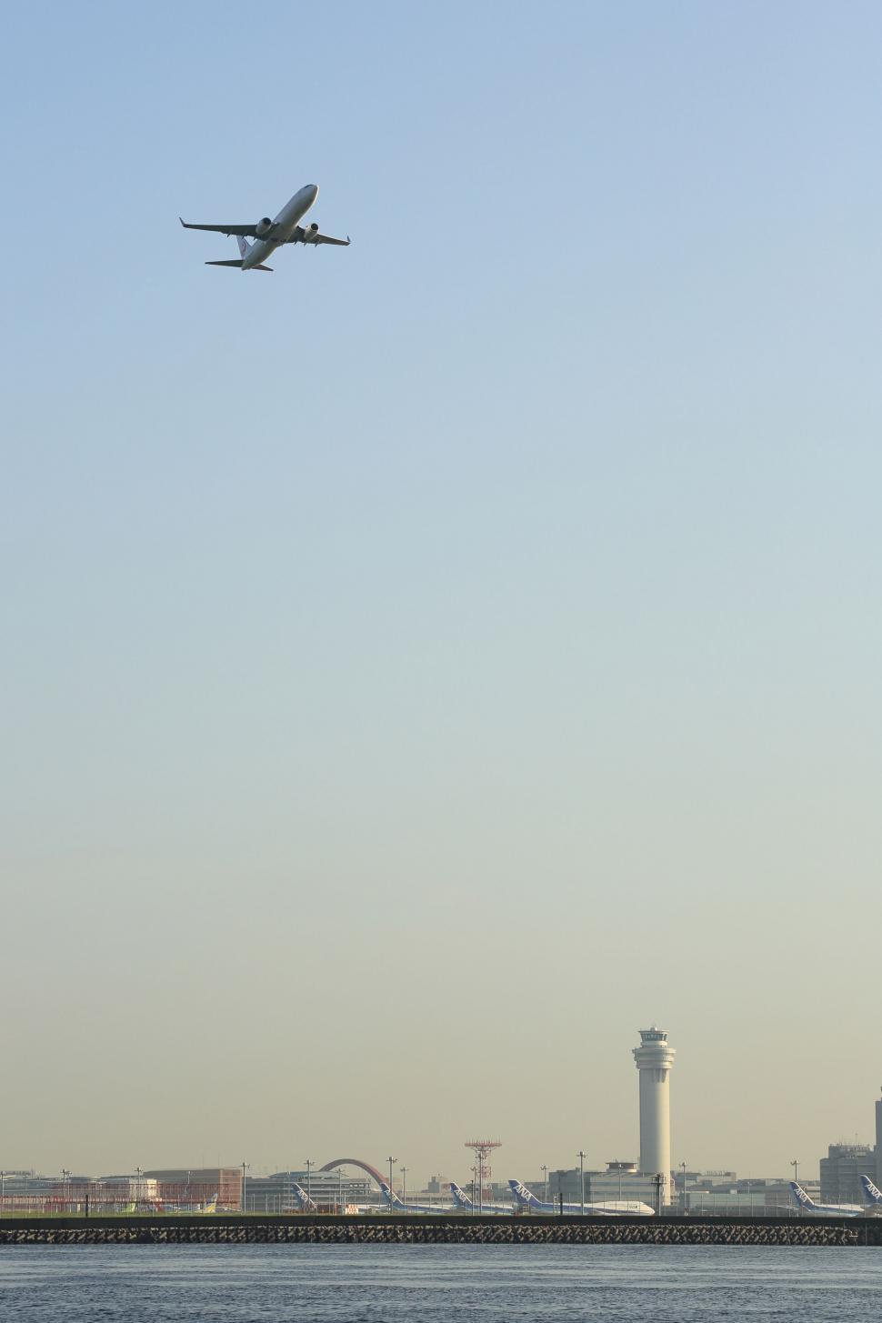 Free Image of Airplane Flying Over a Body of Water 